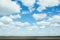 Blue sky background with soft silky clouds and strip field.