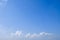 Blue sky background with tiny fluffy clouds. With copy space