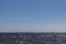 Blue sky and beautiful blue sea with visible in the distance silhouette of a big city with skyscrapers