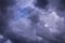 Blue sky behind dark violet storm clouds background texture, thunderstorm