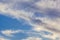 Blue sky with cirrus clouds and contrails at sunset