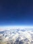 Blue sky, cloud covered earth and mountains