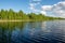 blue sky and cloud reflections in countryside lake in summer with boat and wooden boardwalk