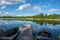 blue sky and cloud reflections in countryside lake in summer with boat and wooden boardwalk