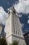 Blue sky with clouds behind white belfry church of Cortina d`Ampezzo, Veneto, Italy.