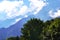 Blue Sky and Clouds, Green Trees and Glacier in Background