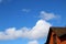 Blue sky with clouds and house roof