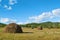 Blue sky and clouds over green hills with haystack