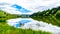 Blue Sky, Clouds and surrounding Mountains reflecting on the smooth water surface of Trapp Lake