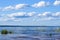 Blue sky with Cumulus clouds over the Lake Ladoga shore