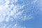 Blue sky with fluffly white scattered clouds day time landscape background
