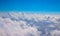 Blue sky with fluffy clouds, natural cloudscape view from plane window. Airplane travel concept. White clouds overcast