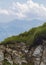 A blue sky and grassy land on the edge of the mountain. with rocks