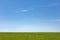 Blue sky, green grass. Horizon. Countryside. Summer sunny day