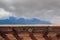 Blue sky with grey clouds over exterior adobe wall, creative copy space, cast shadows