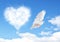 Blue sky with hearts shape clouds and dove.