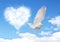 Blue sky with hearts shape clouds and dove.
