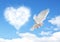 Blue sky with hearts shape clouds and dove.