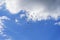 Blue sky with layered cumulus clouds and many flying birds. Natural background.