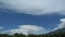 blue sky and light clouds over the mountains at noon