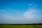 Blue sky with open grass field