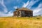 Blue sky over an abandoned home surrounded by junk on the prairies of Saskatchewan