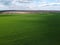 Blue sky over a green field, aerial view. Farmland landscape