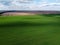 Blue sky over a green field, aerial view. Farmland landscape