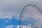 Blue sky over path of large observation Ferris Wheel