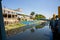 The blue sky is reflected in the black water of the Sadarghat Launch Terminal