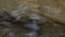 Blue sky reflects on the surface of a weak stream of water