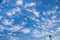 Blue Sky with Scattered White Clouds over Tall Palm Tree