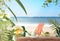 blue sky and sea water wave white sand and seashell  green tropical plant cup of coffee on table  and beautiful roses flowers on
