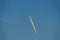 Blue sky with smoke contrail from a rocket or airplane. White cl