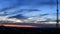 Blue sky with spindrift purple clouds and silhouette of 5G communication tower