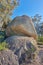 Blue sky, weathered rock and cracked stone from heat exposure and wind erosion along a countryside dirt path. Landscape