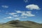 Blue sky with white clouds on bare mountain