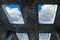 A blue sky with white clouds can be seen through the windows in a concrete building. The concept of faith, freedom and hope.