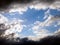 Blue sky and white clouds framed by dark thunderclouds after a thunderstorm. Dramatic impressive illustration. Bright future and