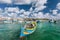 Blue sky white clouds over a fishermen village with colorful boats at Malta. Mediterranean landscape at hot day