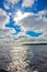 Blue sky and white clouds over Lake Ladoga. Bright sun with rays and highlights