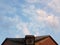 Blue sky with white clouds, roof of the house