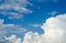 Blue sky in white cumulus clouds. Beautiful peaceful sky with large white and gray storm clouds. Summer sunny day. Good weather.