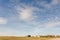 Blue sky with white, fluffy, tender cumulus clouds, yellow field