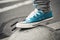 Blue sneaker, teenager foot in urban environment