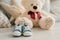 Blue sneakers for baby on the background of soft toys bears