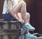 Blue sneakers on girl legs on the grunge background