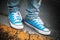 Blue sneakers, teenager feet stands on roadside