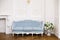 Blue soft sofa in light interior with fabric upholstery.