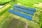 Blue solar photo voltaic panels mounted on metal frame standing on ground with green grass in field